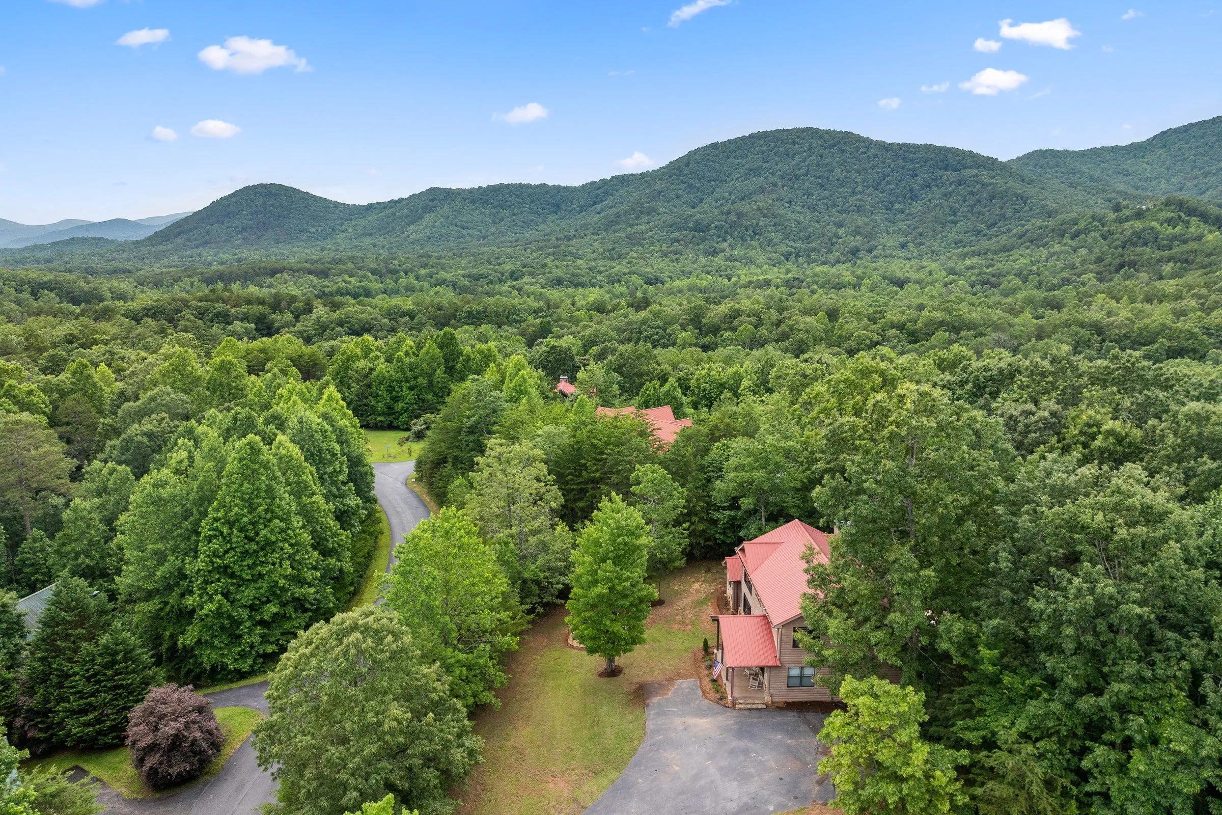 Aerial view of the cabin and driveway below green North Georgia mountains