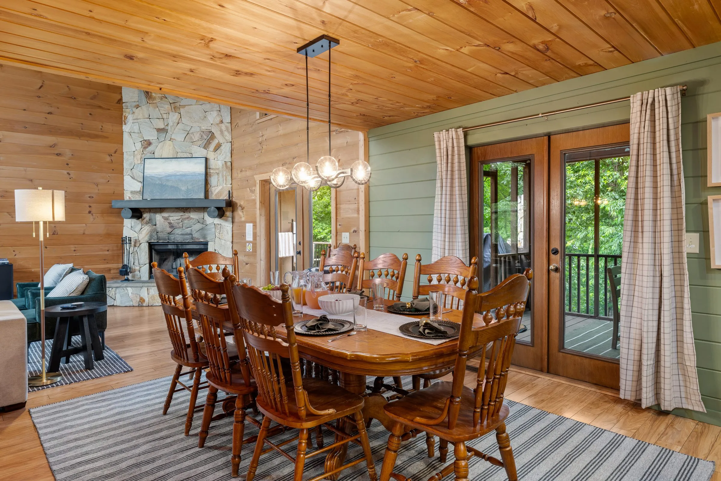 Wood dining table for the group with the stone fireplace and deck doors beyond