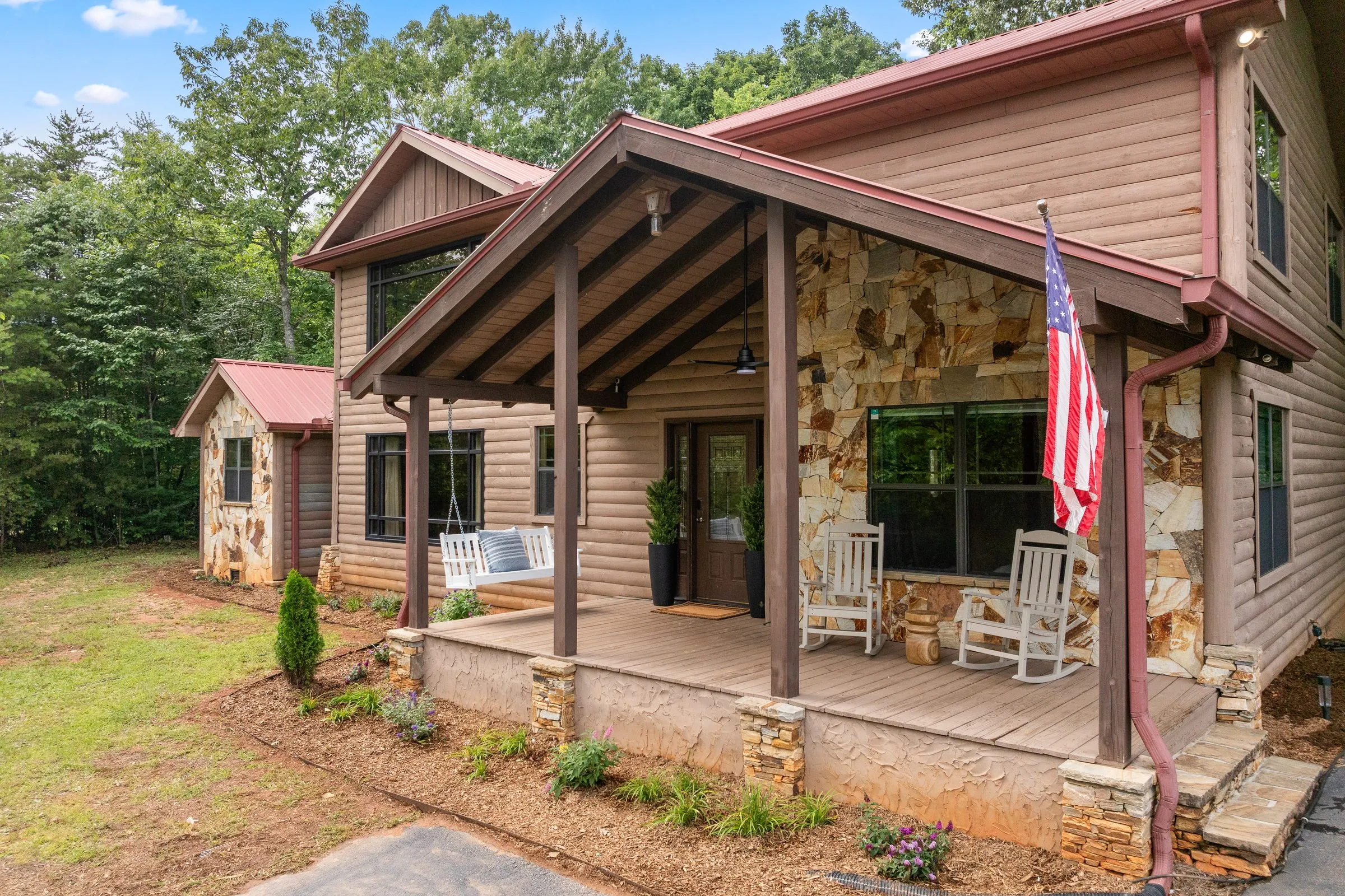 Front porch with white rocking chairs and stone columns